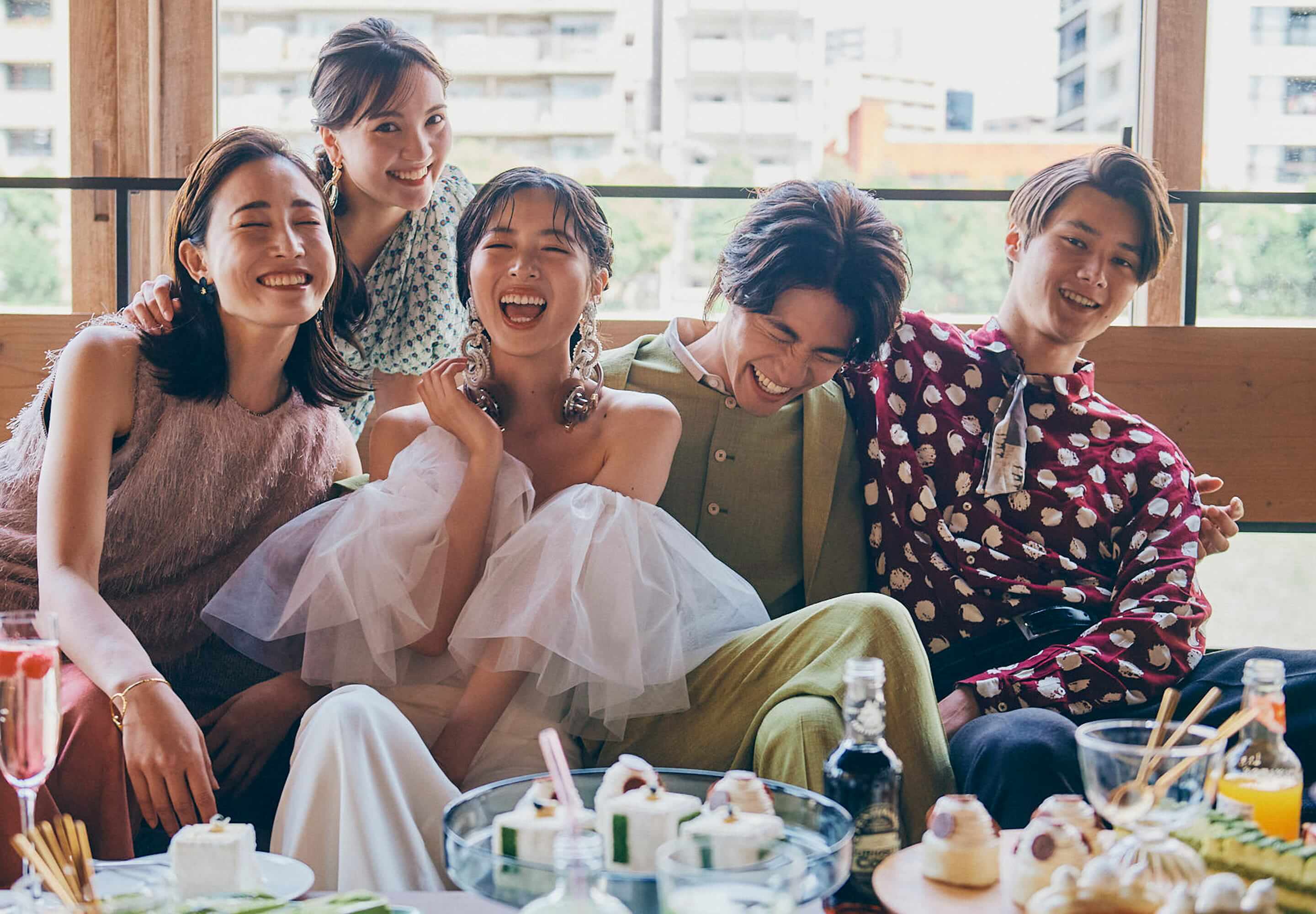 新郎新婦を友人たちが囲んで、笑い合うメインビジュアル